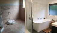 Tiled bathroom with freestanding back to wall bath